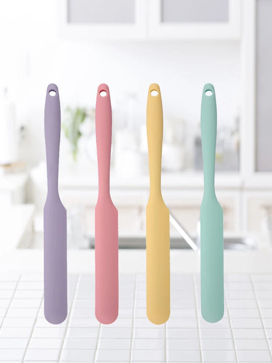 Four colorful spatulas on a white surface with a blurred background