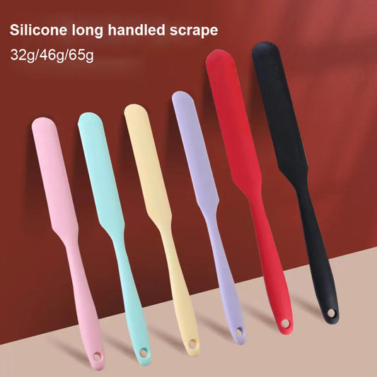 Set of silicone long handled scrapes in various colors on a brown background